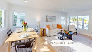 A bright, spacious living room with a dining area, large windows, and a view of the beach. - Beach Condo King Bed Lush Patio w BBQ Birch Key Four (Fort Lauderdale)