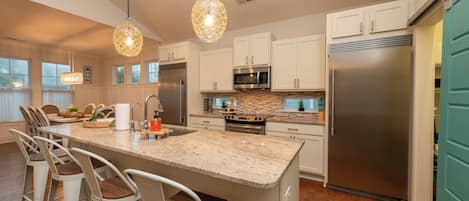 Fully stocked kitchen, seating for 4 at counter, separate fridge and freezer