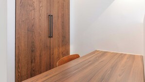 A wooden table with a chair, a wooden wardrobe, and a white wall. - Relaxing Urban Getaway, Notre Dame (Paris)