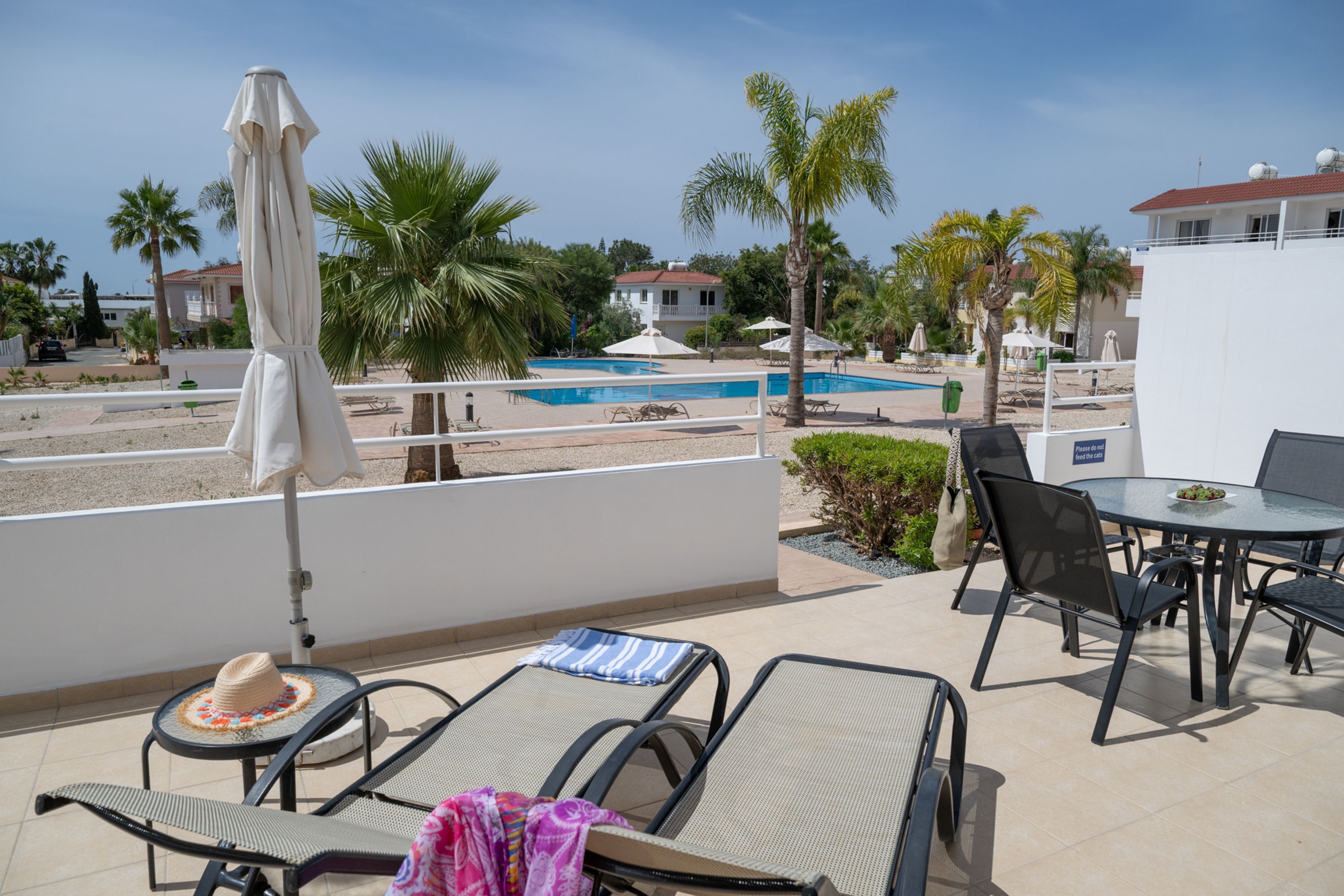 Una terrazza sul tetto con piscina, poltrone prendisole e tavolo da pranzo.