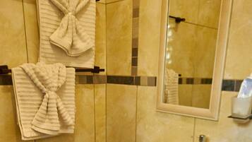 Chuveiro, secador de cabelo, toalhas de banho, papel higiênico