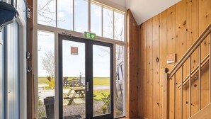 A hotel entrance with a wooden interior, a staircase, and a view of the outside. - Appartement Dijkzicht Near Schagen (Schagen)