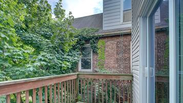 A wooden deck with a brick wall and a window.
