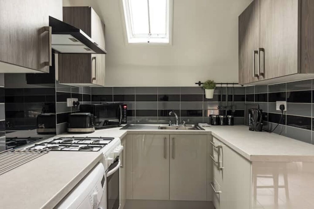 A modern kitchen with a gas stove, microwave, and coffee maker.