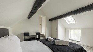 A bedroom with a bed, a desk, a chair, a window, and a skylight. - Entire apartment - Syston The Carpenters Loft (Leicestershire)