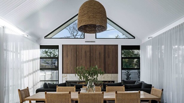 A modern dining room with a high ceiling, large windows, and a central dining table surrounded by wicker chairs. - Maple on Edward Berry - by Linnaeus Collection (Berry)