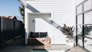 A modern outdoor patio with a built-in seating area, a small pool, and potted plants. - Maple on Edward Berry - by Linnaeus Collection (Berry)