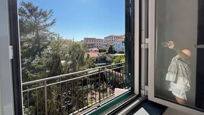 A balcony with a metal railing overlooking a residential area with houses and trees. - Cappuccini's B&B (Livorno)