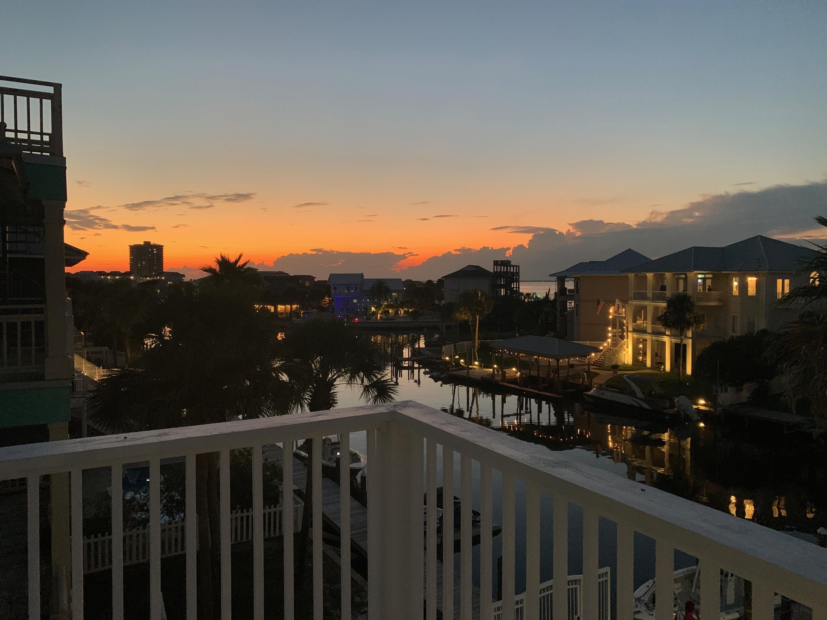 En ejendom ved vandet med balkon, udsigt over en lysthavn, med bygninger der også har balkon og frit udsyn til vandet.
