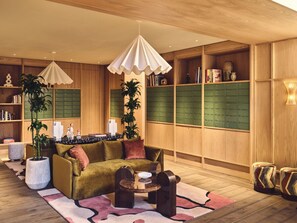 A modern living room with a sofa, coffee table, and decorative plants.