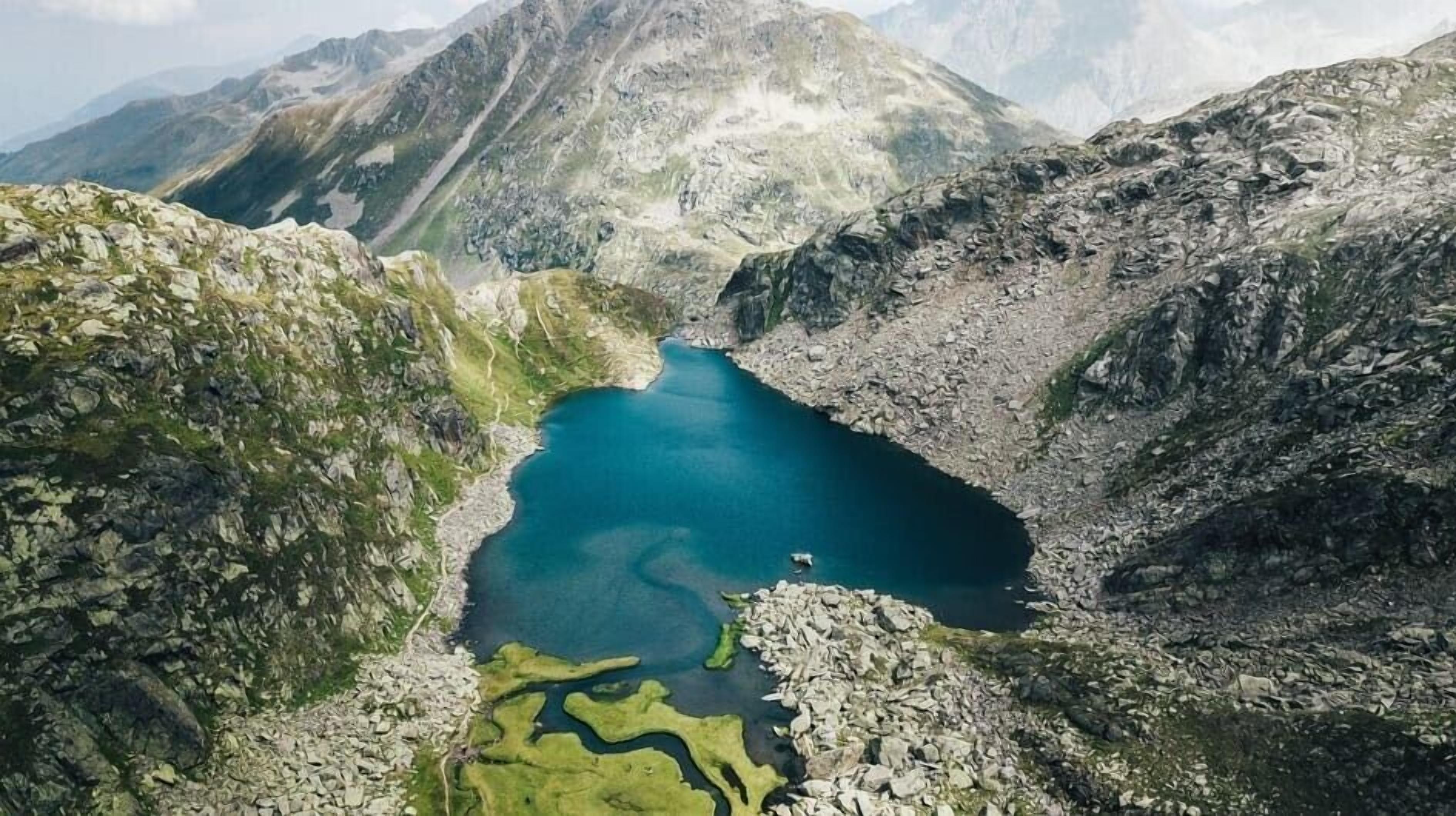Un paysage montagneux avec un lac entouré de reliefs rocheux.
