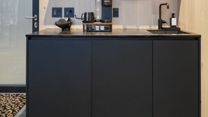 Une cuisine moderne équipée d’un climatiseur intégré, d’une machine à café et d’un évier.