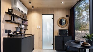 Une cuisine moderne équipée d’une machine à café, d’un four à micro-ondes et d’un coin repas avec une table et des chaises.