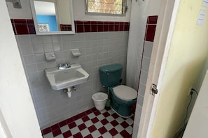 A small bathroom with a sink, toilet, and a mirror. - 01 Casa Naranja in Isla Mujeres (Isla Mujeres)
