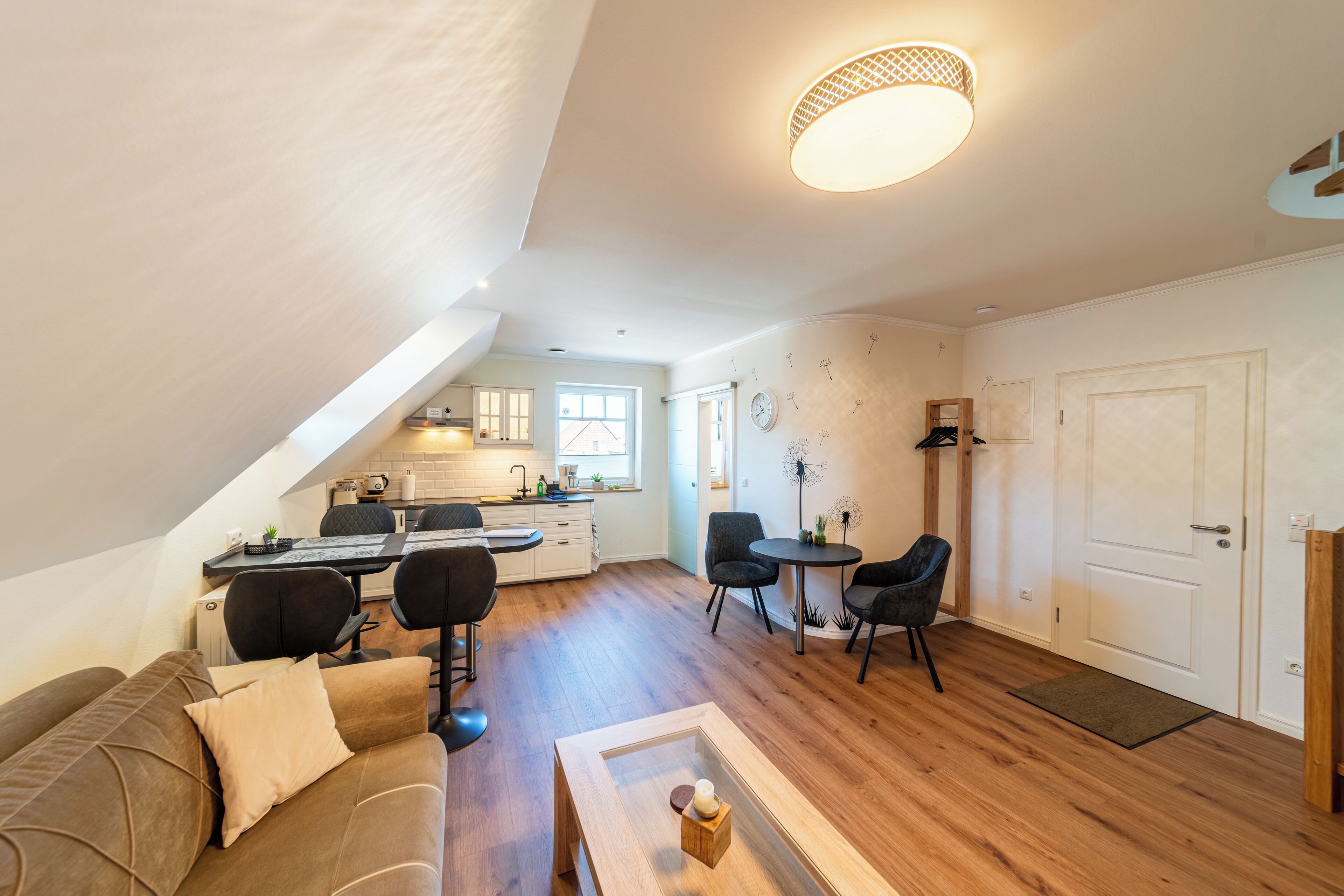 A modern loft apartment with a dining area, kitchen, and living space.