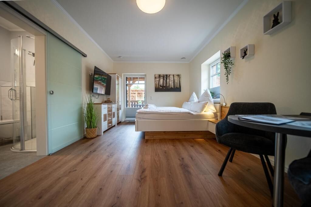 Een moderne slaapkamer met een bed, nachtkastje en een stoel.