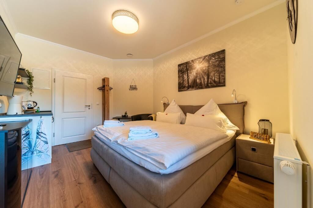 A bedroom with a bed, bedside table, and a nightstand.
