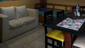 Un comedor con techo de madera, un sofá y dos cuadros en las paredes.