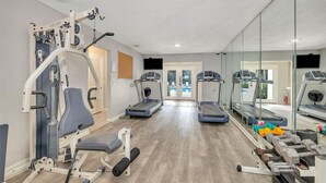 A gym with treadmills, a weight bench, and free weights.
