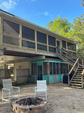 A two-story building with a covered porch, a fire pit, and a staircase leading to the upper level. - Beach/Marina/Walking trails and more… (Carrabelle)