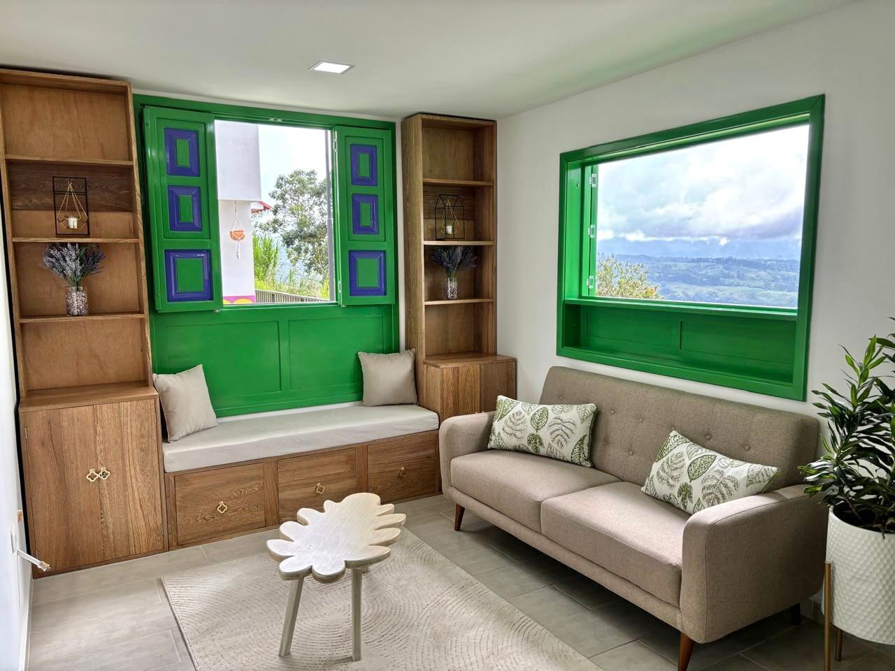 Ein gemütliches Wohnzimmer mit einer eingebauten Bank, einem Sofa und Blick ins Freie.