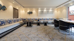 A modern interior with a long bench, a dining table, and chairs.