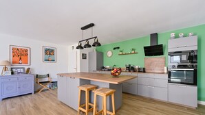 Una cocina moderna con una isla central, armarios grises, un microondas y un horno.