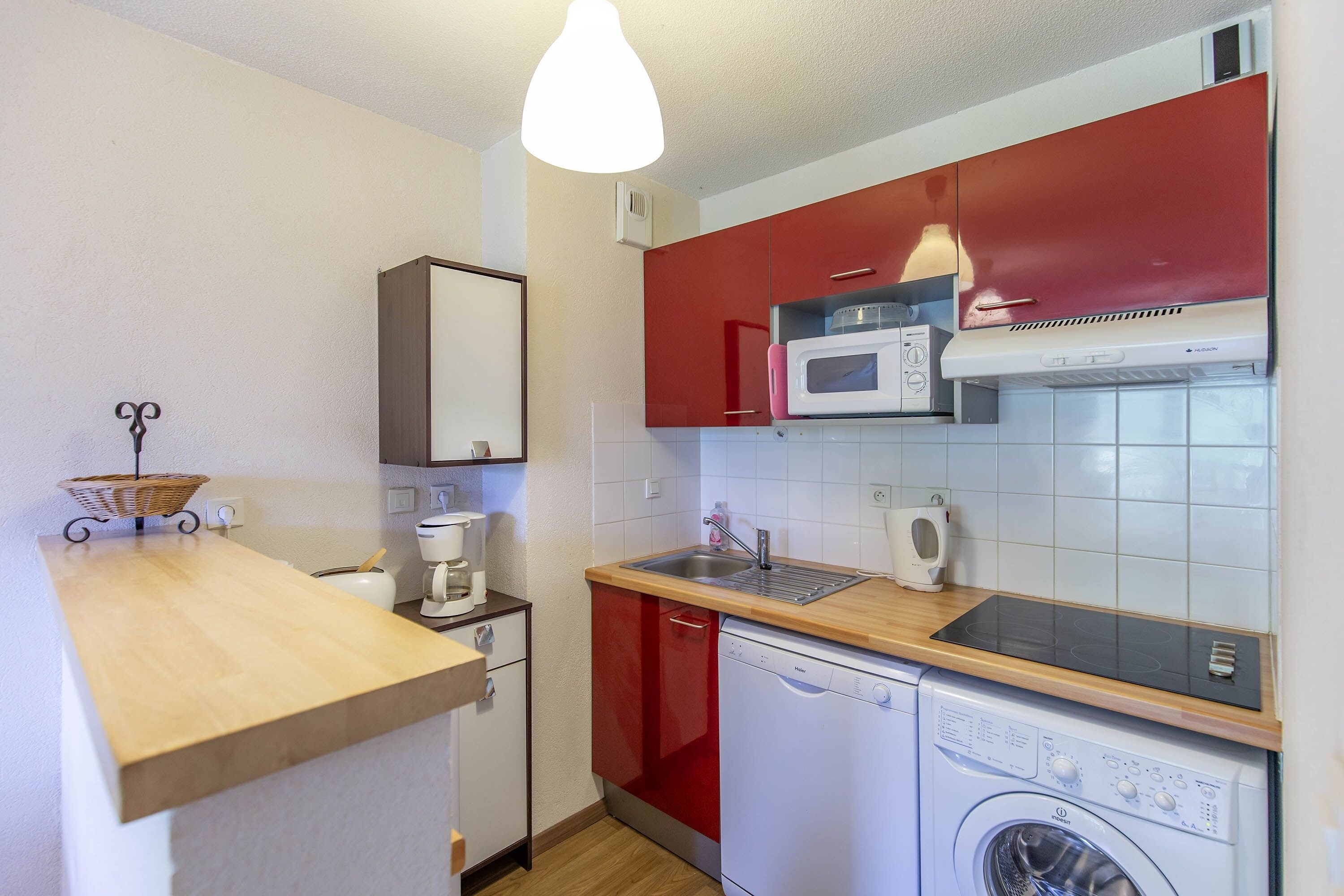 A compact kitchen with a microwave, toaster, and dishwasher.