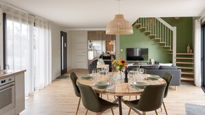 Eine moderne Küche mit Essbereich, einer Treppe und einem Wohnzimmer mit Fernseher.