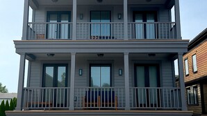 Een woongebouw met twee verdiepingen, een balkon op de begane grond en een balkon op de tweede verdieping.