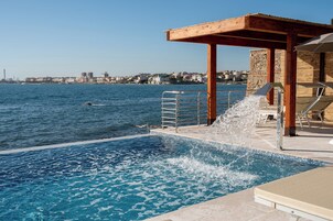 Una piscina al aire libre, sombrillas, tumbonas