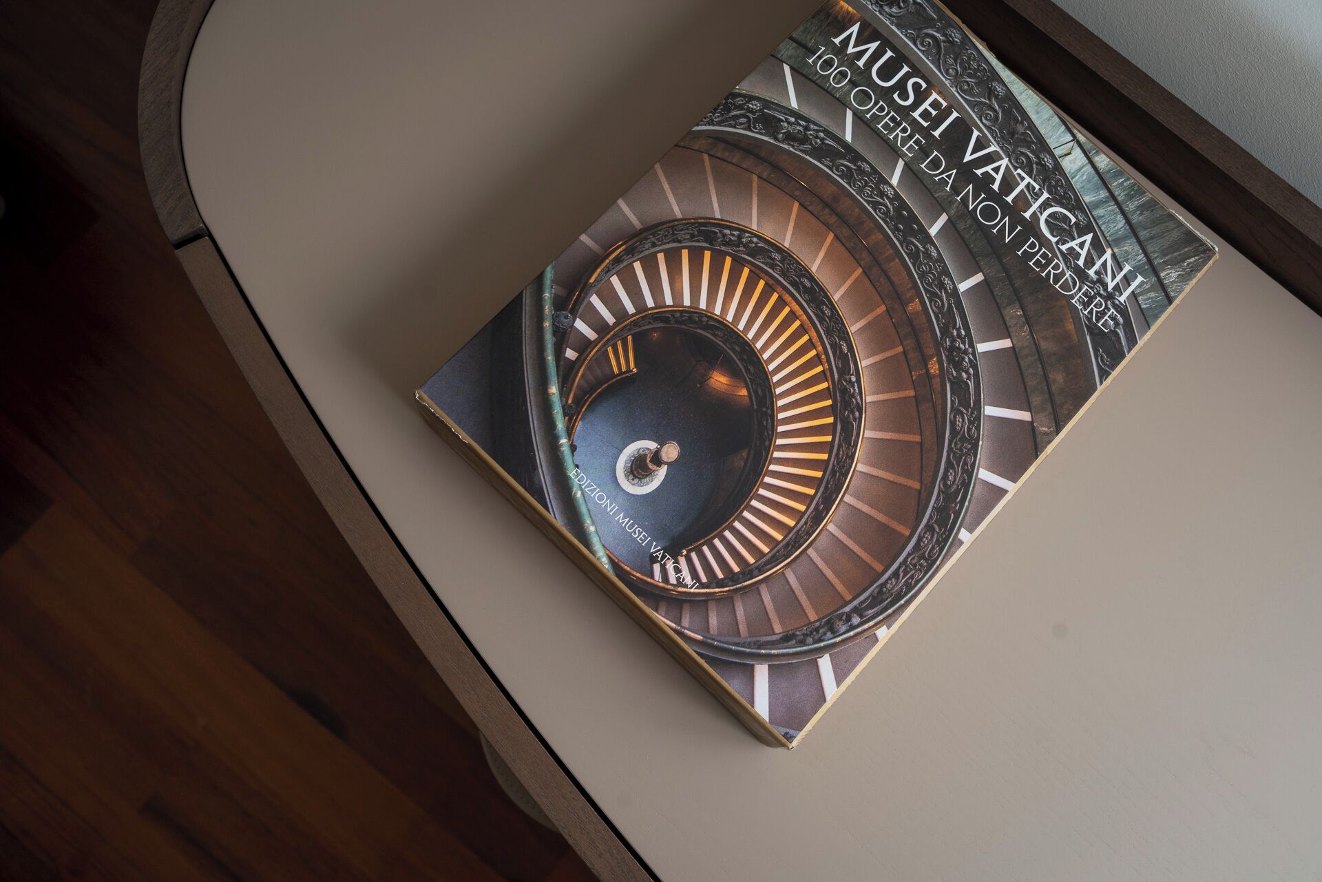 Ein Buch mit dem Titel 'Musei Vaticani 100 opere da non perdere' auf einem Tisch.