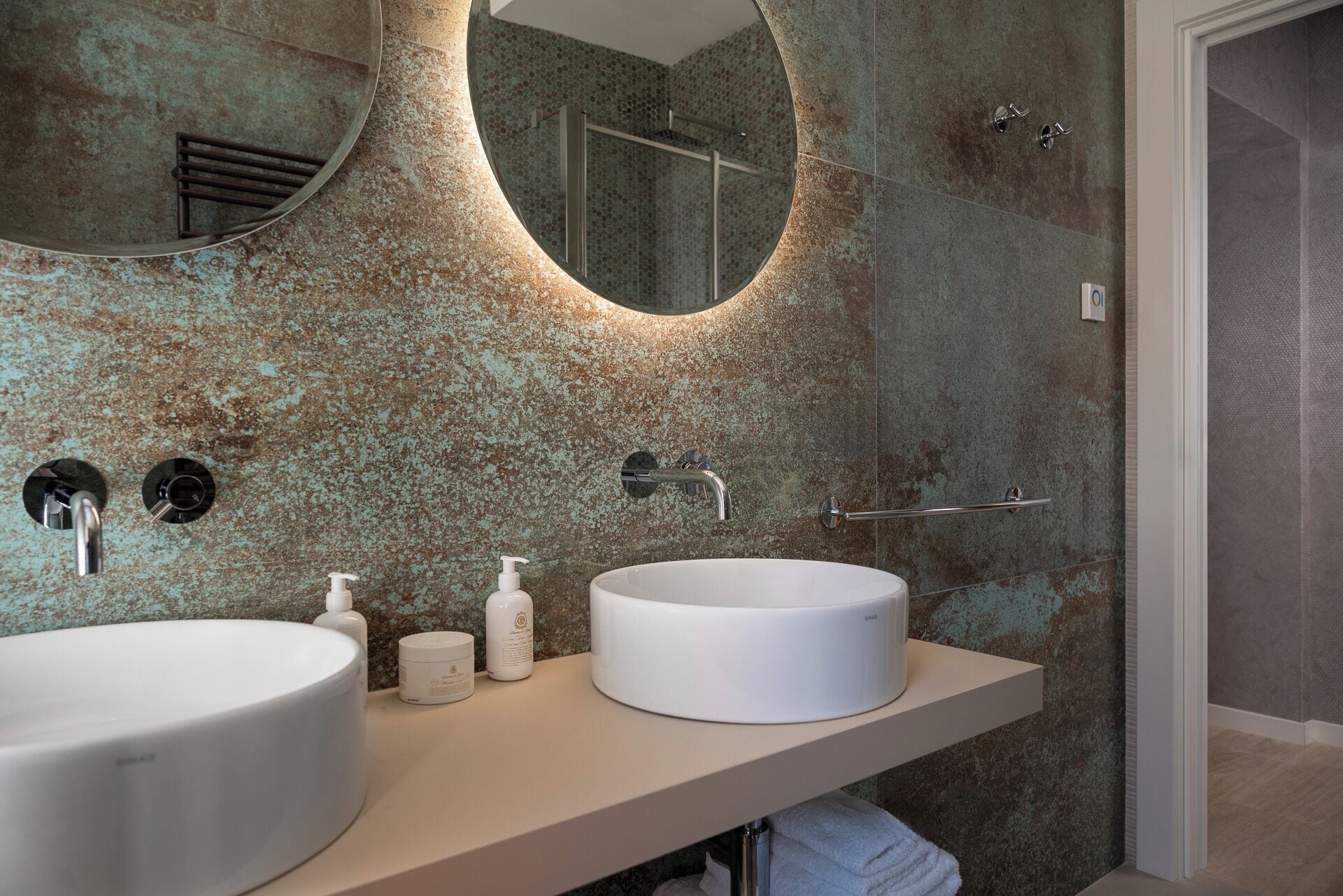 A bathroom with a round sink, a mirror, and a shower.