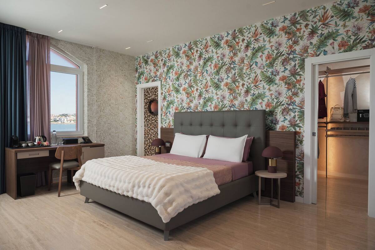 Un dormitorio con cama, escritorio, silla, mesita de noche y armario.