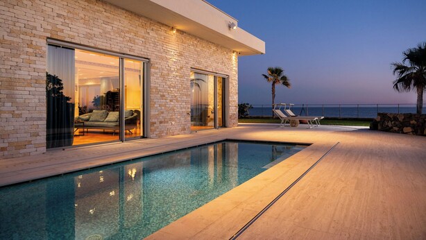 A modern house with a swimming pool, a patio with lounge chairs, and a view of the sea. - Villa Giada Luxury Boutique (Civitavecchia)