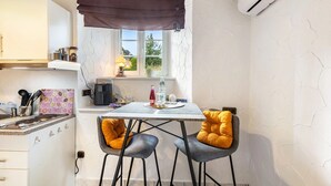 A compact kitchen with a window, a table with two chairs, and a hanging light fixture. - Apartment Schlossmühle in Bigge-Olsberg (Olsberg)
