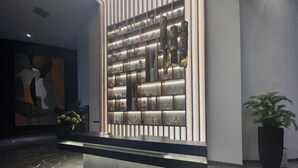 A modern lobby with a marble floor, a decorative wall with various items, and a large abstract painting. - Hotel Soho Boutique Casablanca (Casablanca)