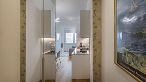 Habitación de hotel moderna con un espejo grande, un cuadro de un velero y vistas a la ciudad.