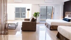 Una habitación de hotel moderna con una cama, un sofá, una mesita y un balcón con vistas.