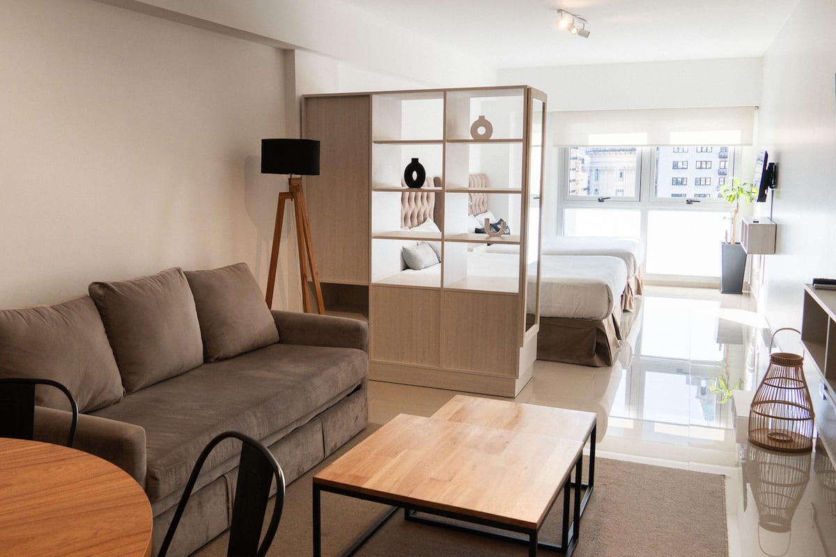 Een moderne woonkamer met een bank, een salontafel, een boekenkast en een televisie.