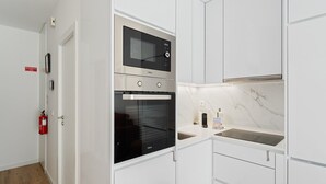 A modern kitchen with a built-in microwave, oven, and stainless steel countertops.