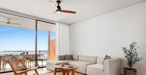 A modern living room with a sofa, coffee table, and chairs, large windows with a view, and a ceiling fan. - Valley | Sea view - pool - terrace (Fuengirola)