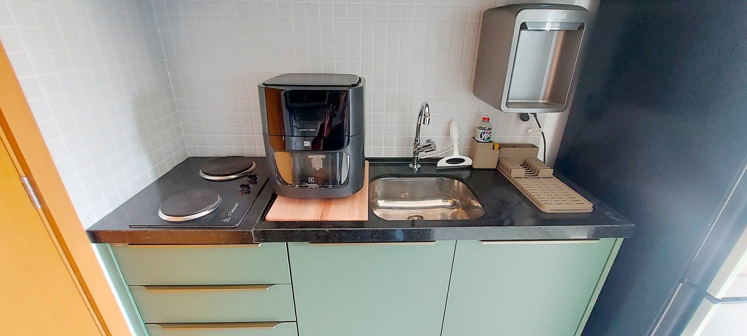 Una cocina compacta equipada con cafetera, tostadora, pileta y microondas.