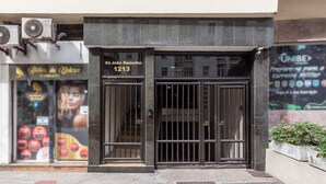 A building entrance with a metal gate, a sign with a name and number, and a storefront with a poster. - 6 Minutes From Copacabana Beach Nsc904b (Rio de Janeiro)