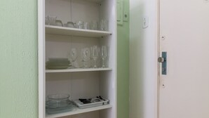 A white shelving unit with glassware, bowls, and storage bins against a light green wall. - 6 Minutes From Copacabana Beach Nsc904b (Rio de Janeiro)