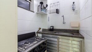 A compact kitchen with a gas stove, a sink, and a small countertop. - 6 Minutes From Copacabana Beach Nsc904b (Rio de Janeiro)