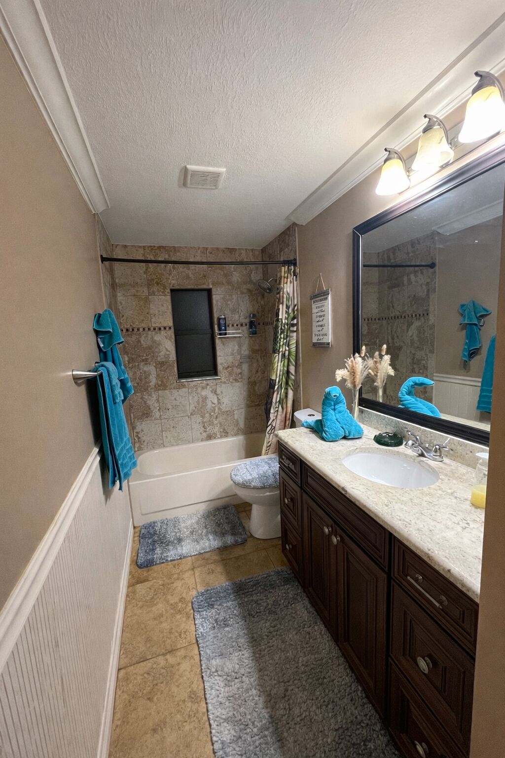 A bathroom with a bathtub, toilet, sink, and mirror.
