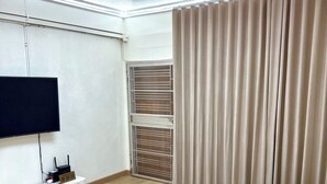 Une chambre moderne avec un grand lit, un téléviseur à écran plat, un luminaire au plafond et une porte coulissante.