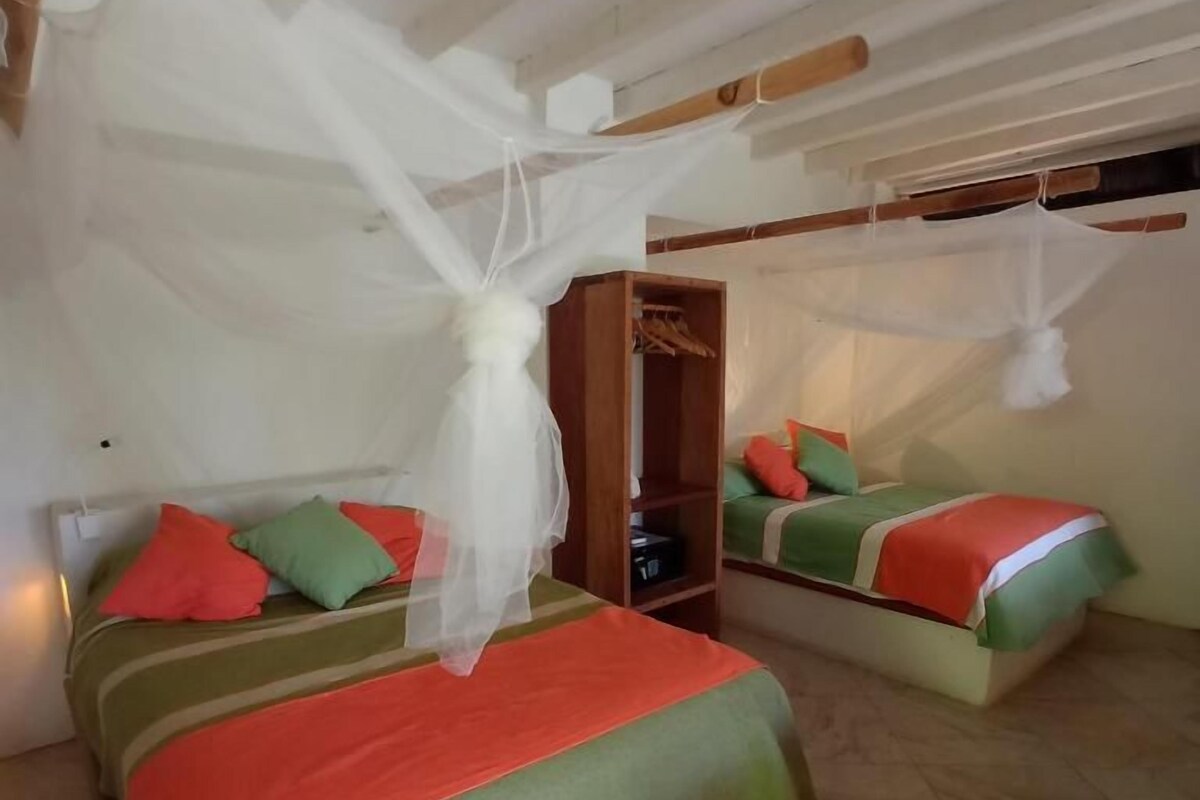 A room with two beds, each with a canopy, and a wardrobe.