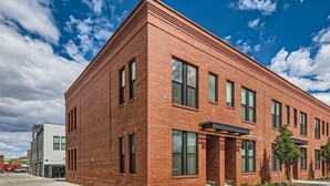 A red brick building with large windows and a flat roof.